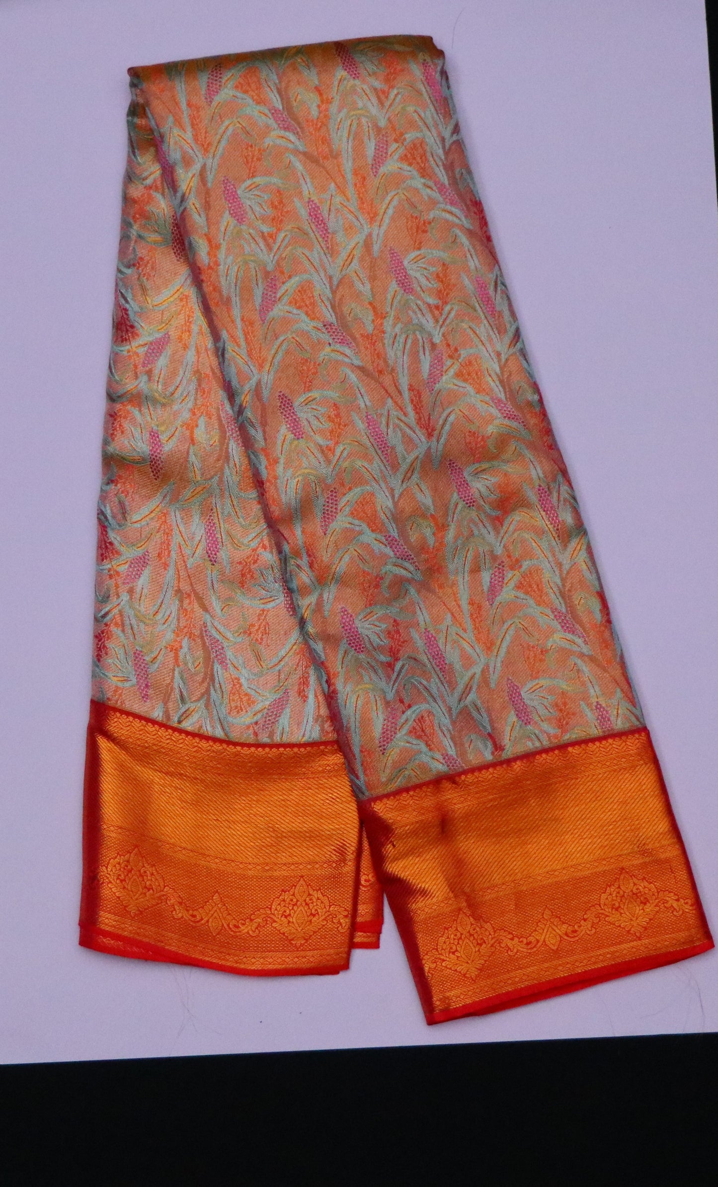 Kanchi Silk-Body-Soft peach–coral base-Mint green leafy motifs-Palu-Border-Rich burnt orange