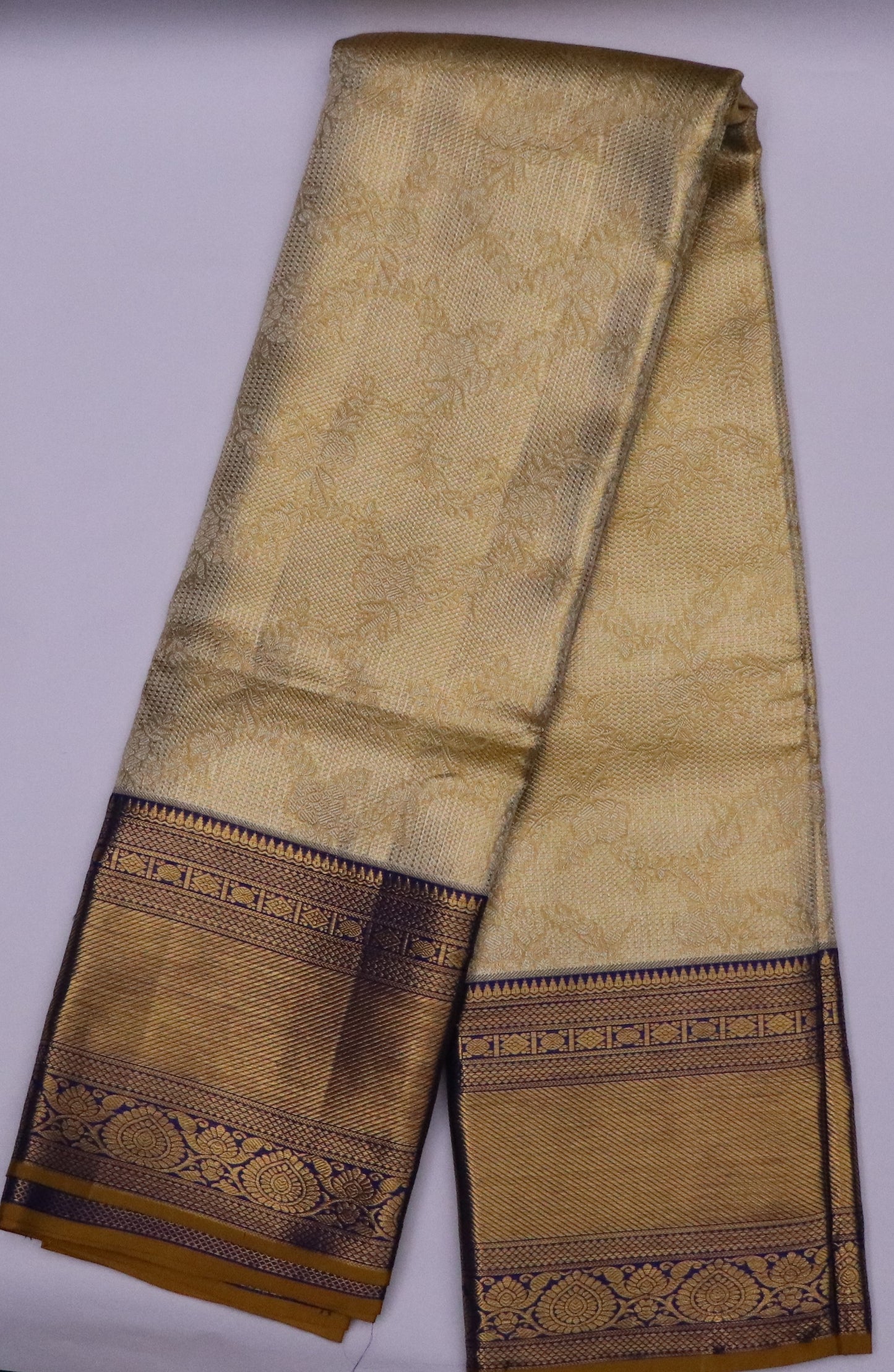 Kanchi Silk-Body-soft antique gold-cream-gold and honey-gold-self-jacquard floral pattern-deep antique gold zari with dark navy/ink-blue accents