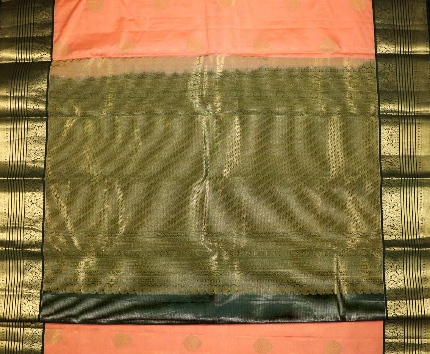 Kanchi Silks-Body-Warm Peach–Salmon Tone-Round gold zari buttas-Border-zari border-Deep olive-black undertone.