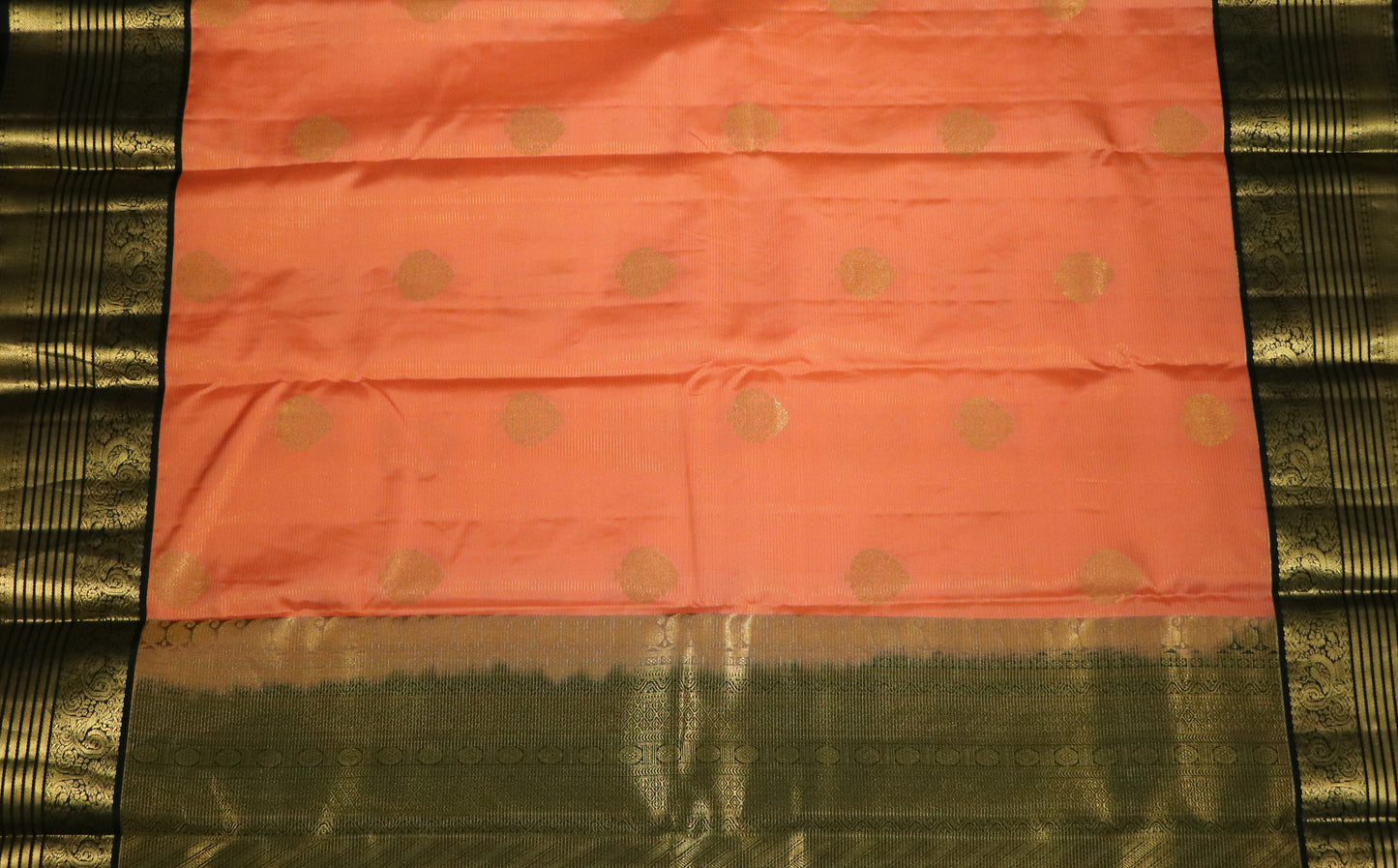 Kanchi Silks-Body-Warm Peach–Salmon Tone-Round gold zari buttas-Border-zari border-Deep olive-black undertone.
